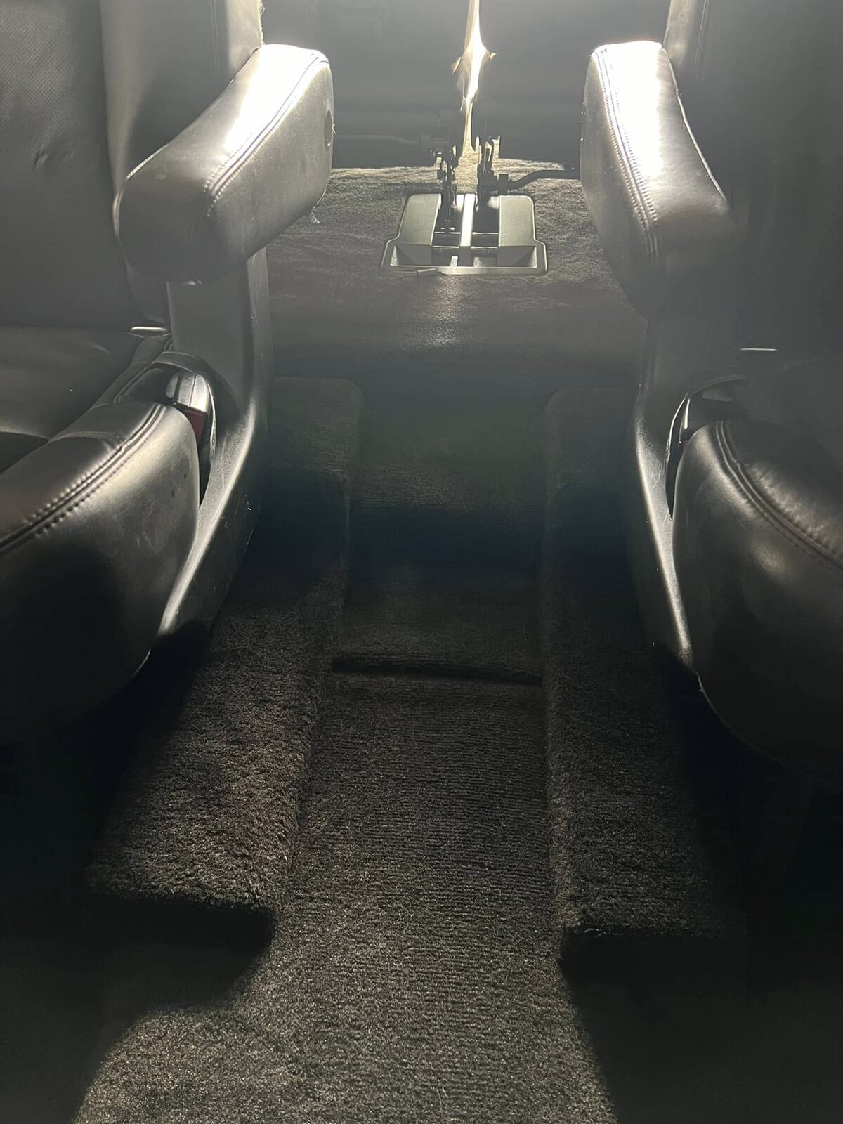 The same rear floor after a full carpet extraction, clean with fresh vacuum lines