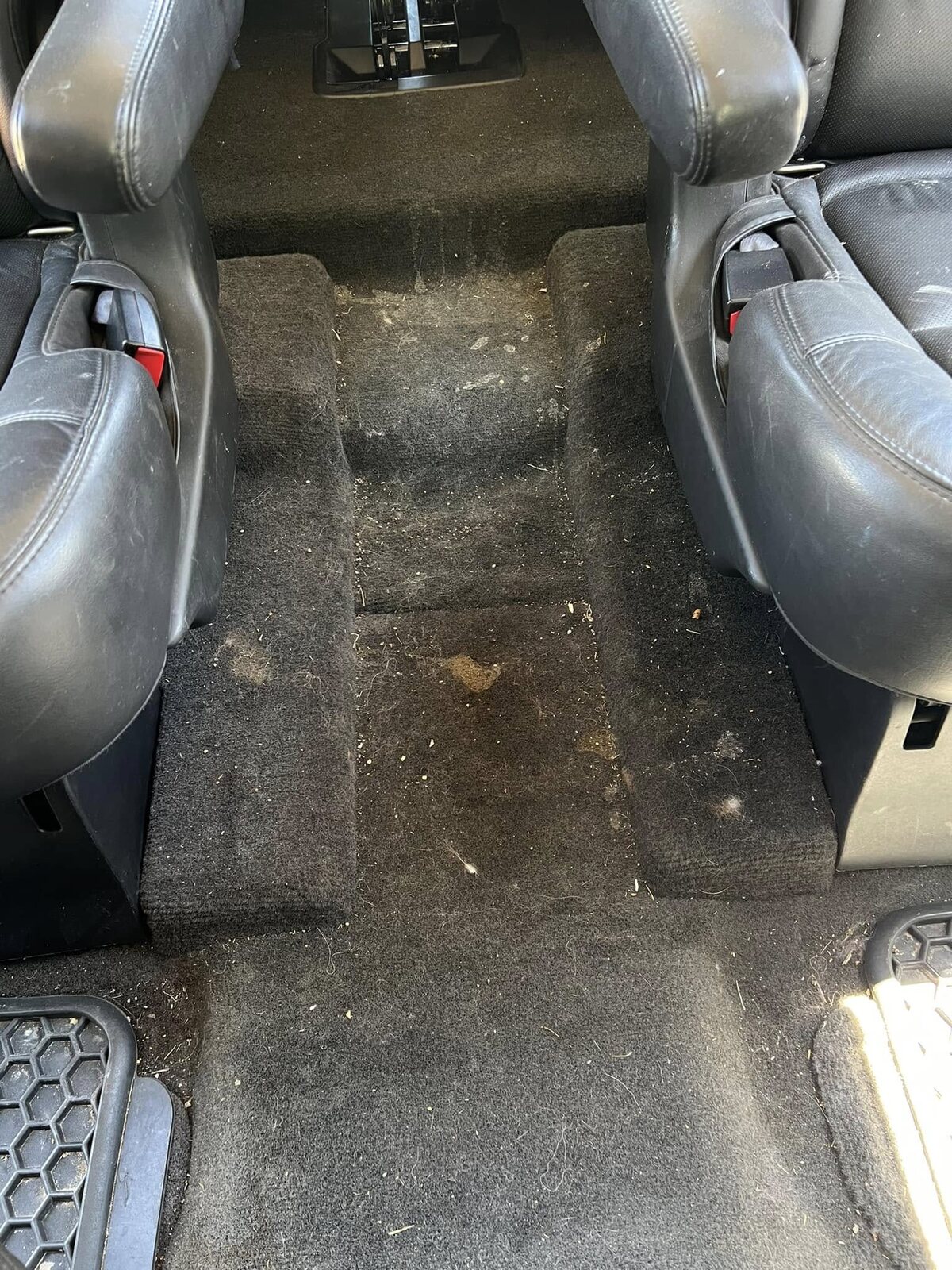 Rear floor carpet covered in dirt and debris before detailing