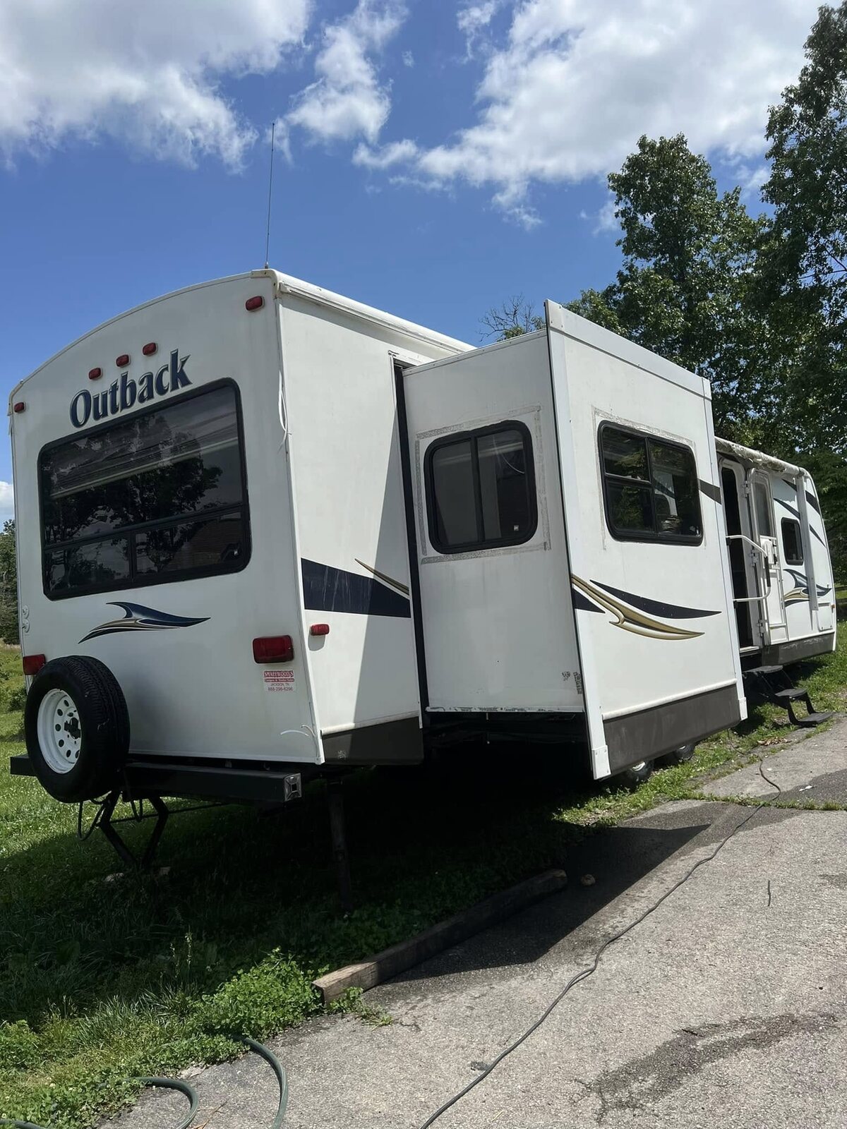 The same travel trailer after a full exterior wash, clean white with the streaking removed